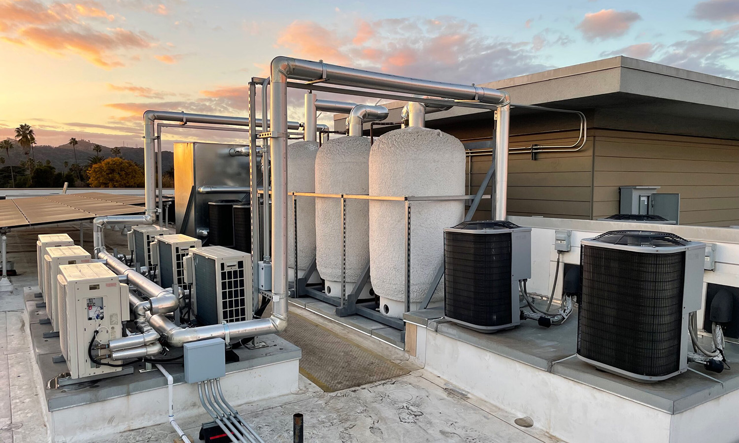 Heritage Square Apts (1500x900) The main terminal building of King County International Airport (Boeing Field) in Seattle, WA, featuring a red brick façade, arched windows, a clock, and an American flag flying above against a clear blue sky.