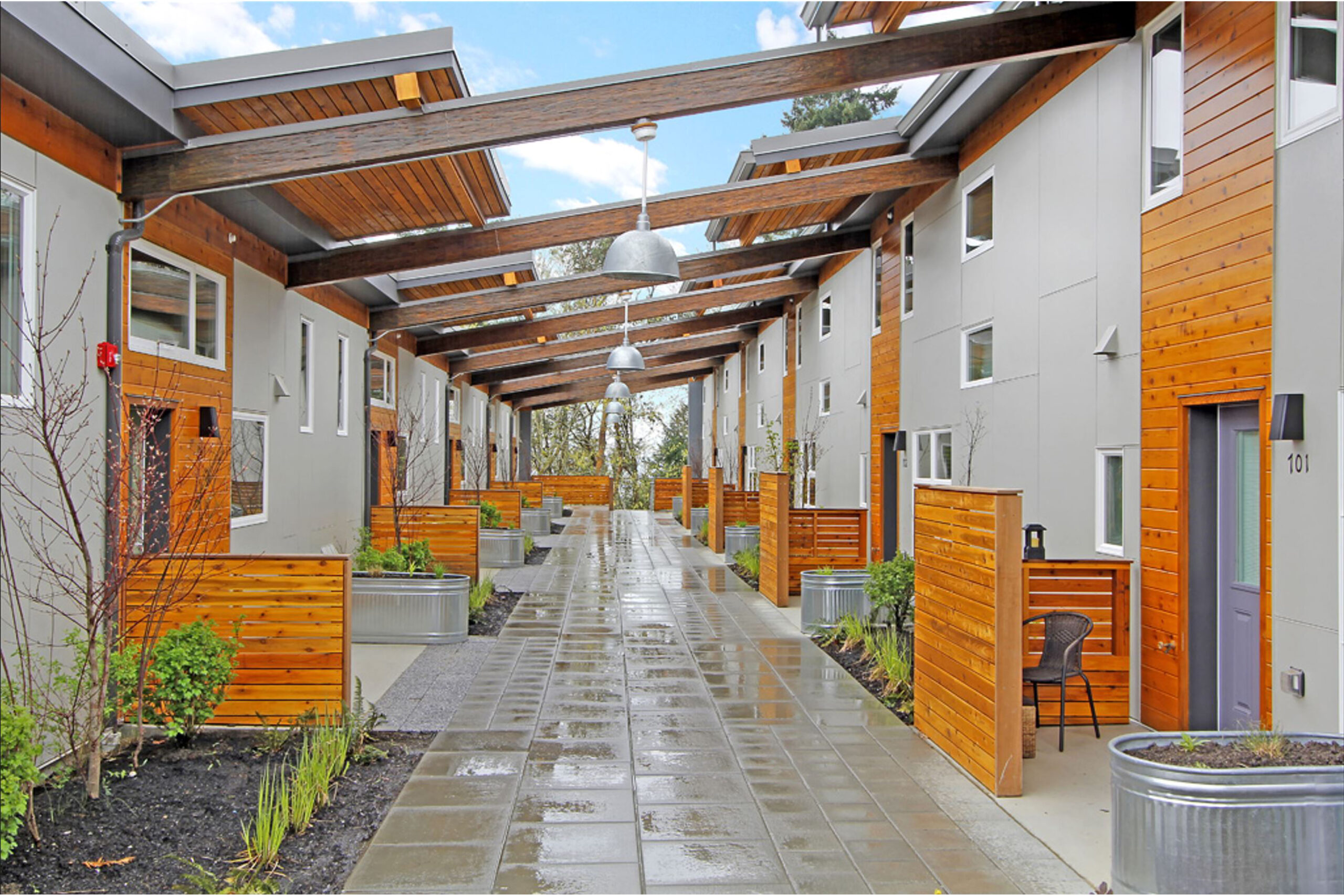The main terminal building of King County International Airport (Boeing Field) in Seattle, WA, featuring a red brick façade, arched windows, a clock, and an American flag flying above against a clear blue sky.