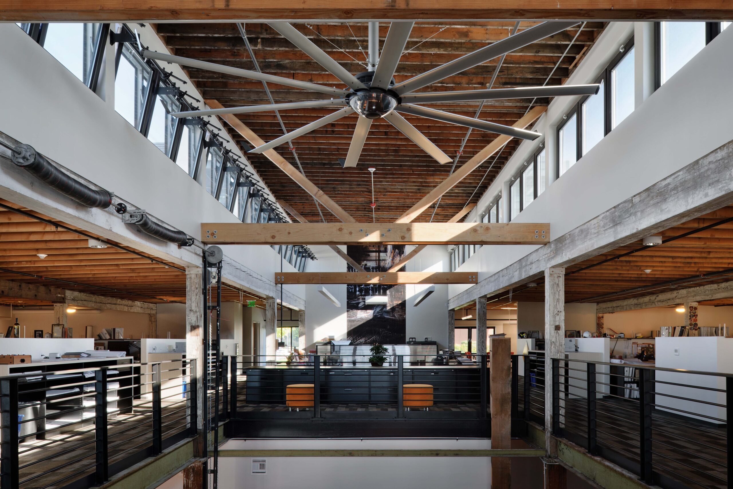 The main terminal building of King County International Airport (Boeing Field) in Seattle, WA, featuring a red brick façade, arched windows, a clock, and an American flag flying above against a clear blue sky.