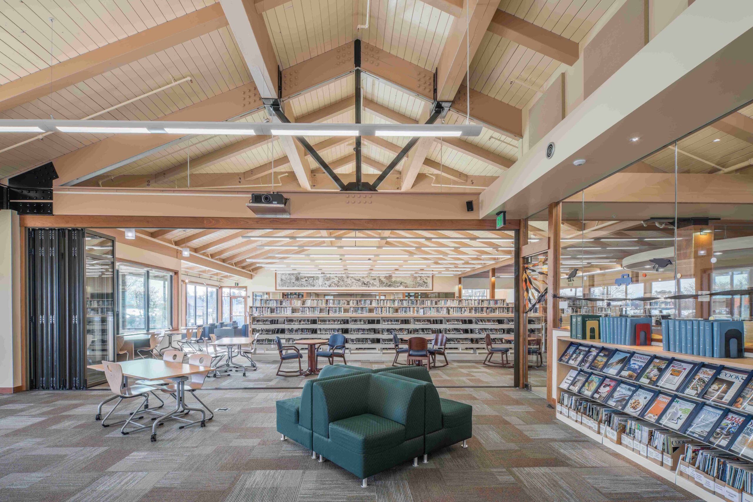 HopeWorks Station, a modern mixed-use building in Seattle, WA, featuring retail spaces on the ground floor and residential units above. The façade includes textured siding, operable window shades, and a rooftop terrace.